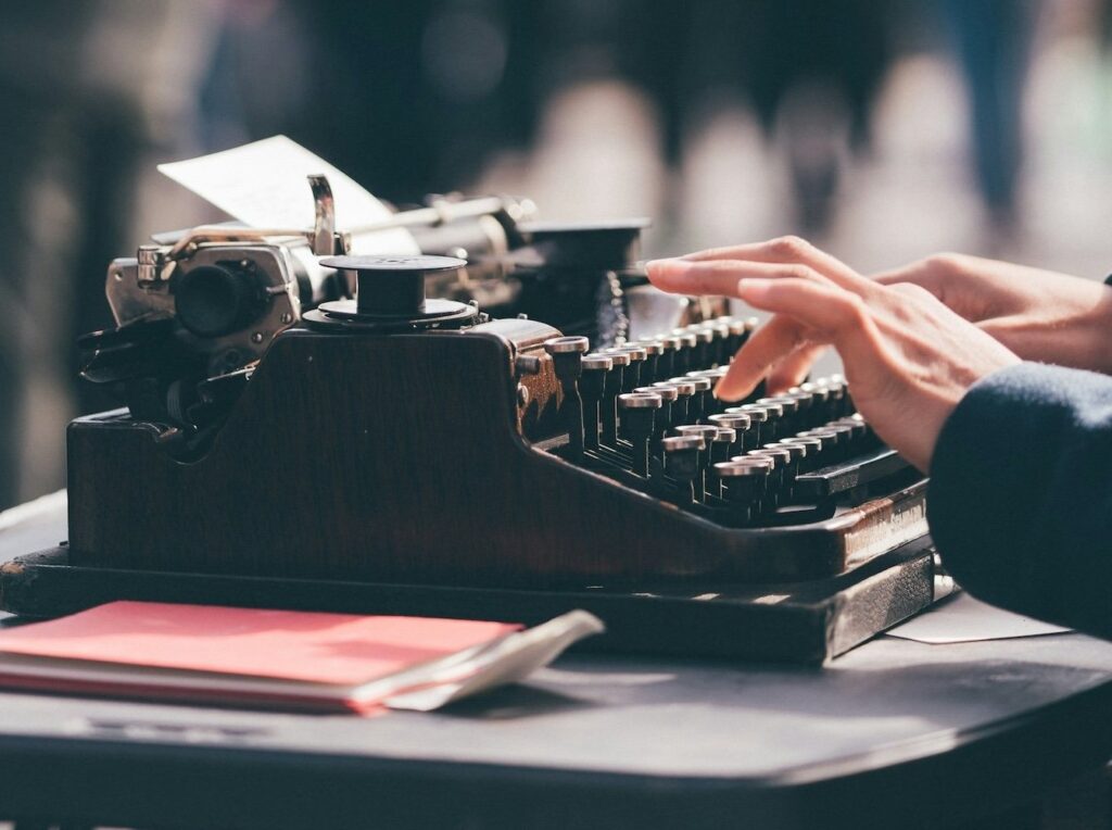 writer hands at old typewriter